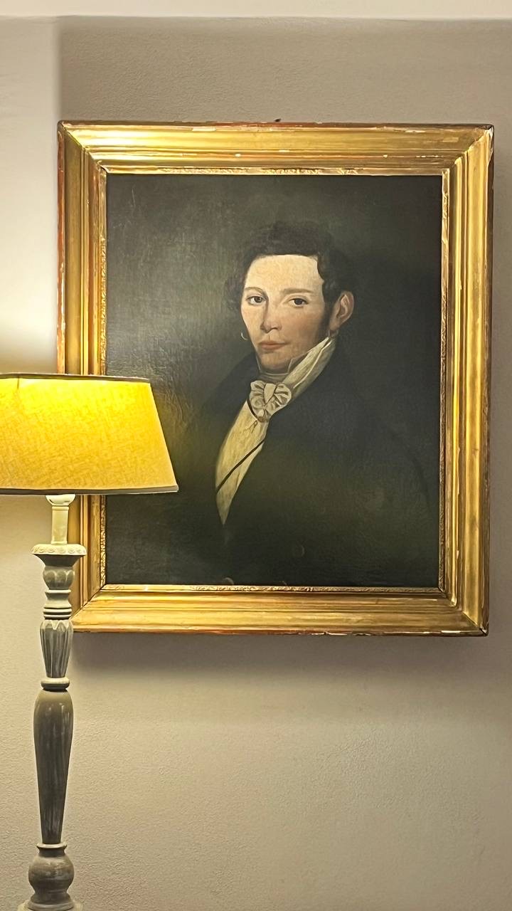 Retrato do século XIX em moldura dourada ao lado de um abajur