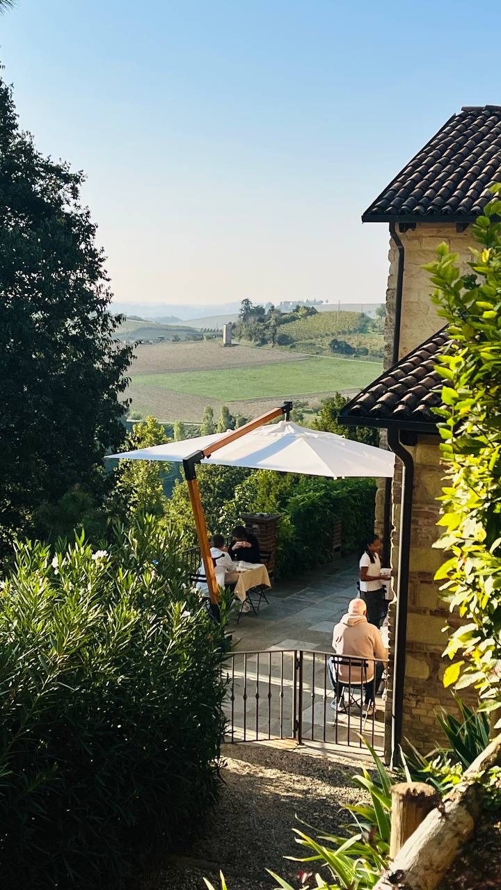 Hóspedes à mesa em um terraço com vista para as colinas