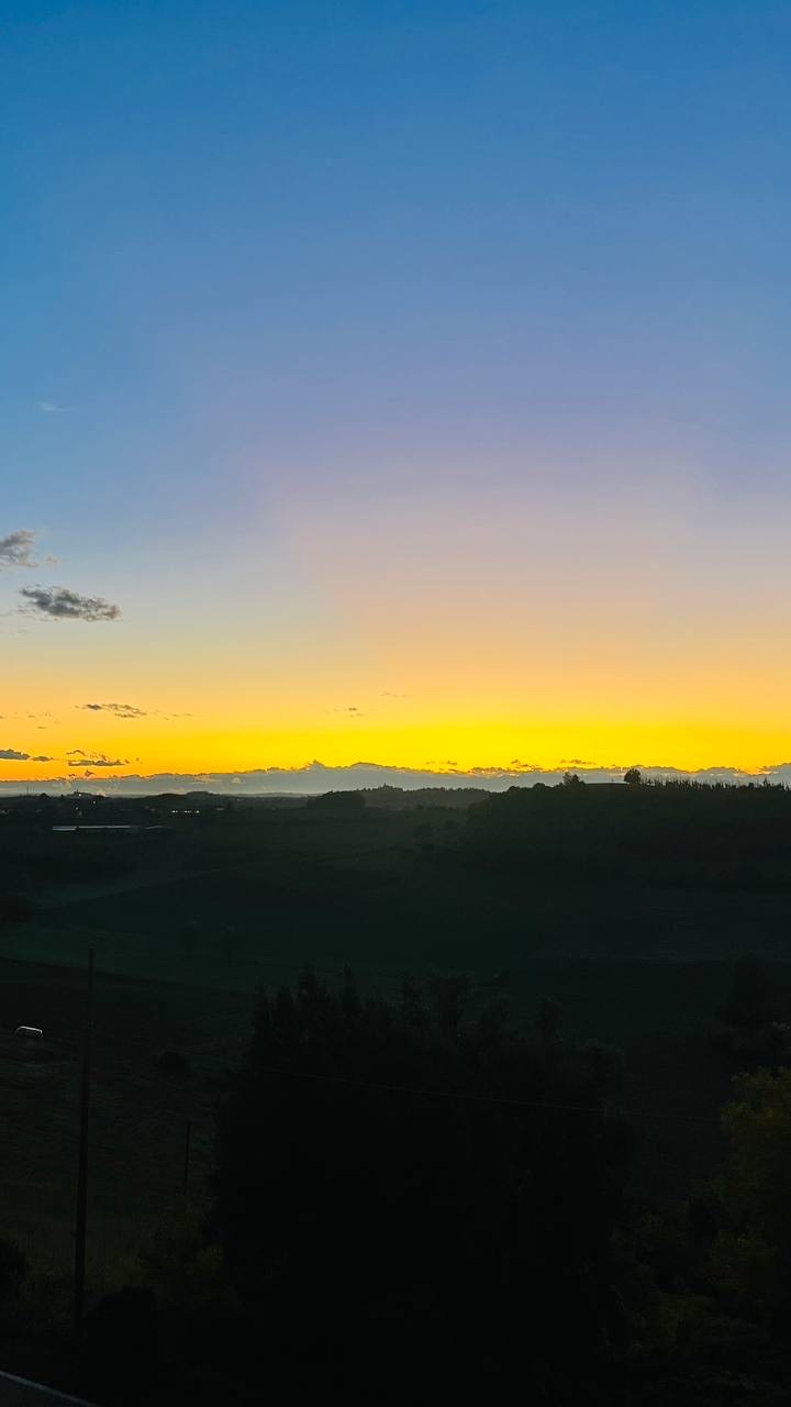 Pôr do sol amarelo no horizonte sobre as colinas